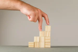 Honeyview Honeyview business growth concept on grey and white wall side view man putting fingers on step stairs 3